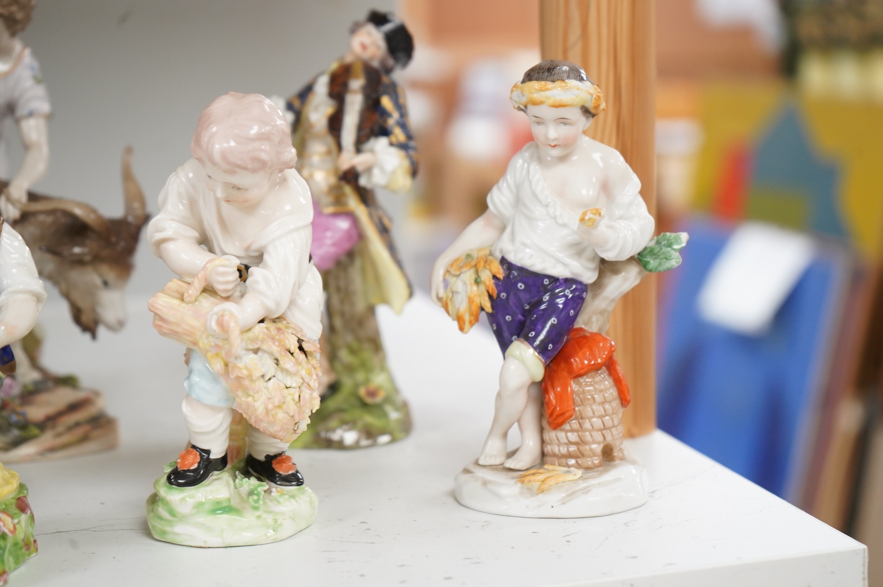 Two Derby porcelain seated figures emblematic of summer and autumn and a collection of Continental porcelain figures to include a pair of recumbent cows, largest 18cm high